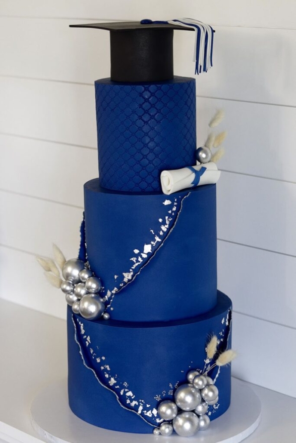 blue graduation cake with cap on top